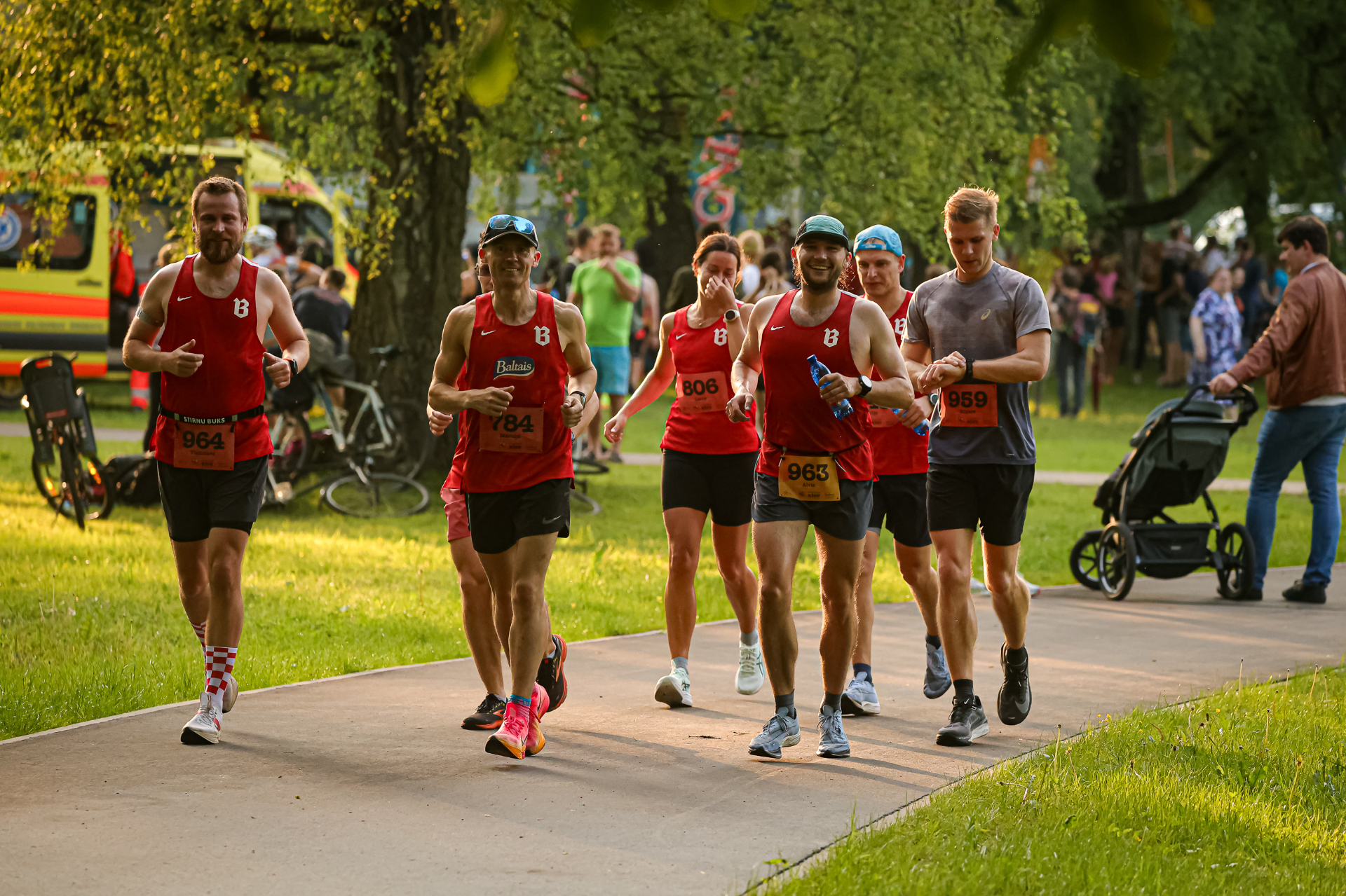 Runners training together at golden hour along the Daugava river in Riga